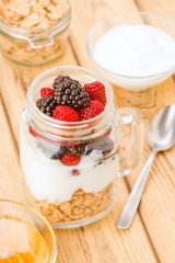 transparent jar with berries and yogurt cereals