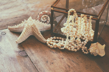 image of white pearls necklace and seashells