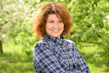 curly smiling middle-aged woman outside
