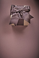 Gift box on brown surface vertical image holidays concept