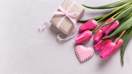 Bright pink spring tulips, decorative heart and box with gift  o