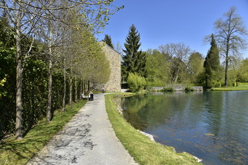 Fototapeta na wymiar Superbe promenade le long de l'étang du Moulin près de l'ancien moulin à eau aux Jardins d'Eau d'Annevoie
