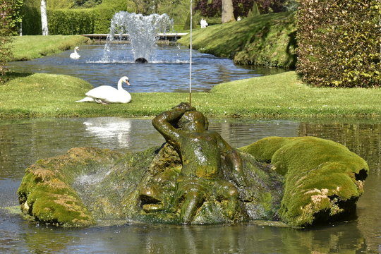 La "cracheur" au milieu de la pièce d'eau décagonale sous le soleil aux Jardins d'Eau d'Annevoie 