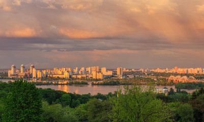 Fototapeta na wymiar View of Kiev city from Botanic Garden before storm at sunset 