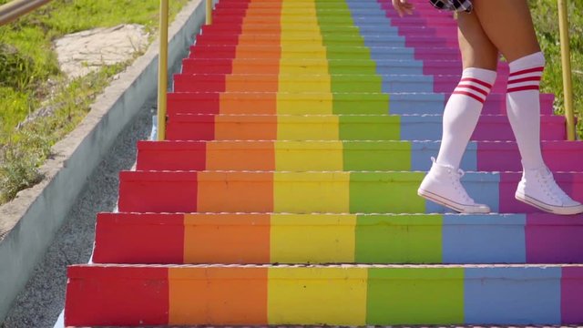 Low section of woman standing on rainbow colored stairs