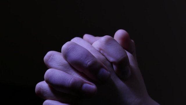 Teen girl is looking for an aid praying. Hands closeup. 4K UHD.