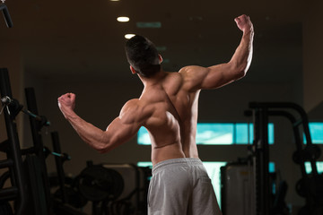 Fototapeta na wymiar Biceps Pose Of A Young Man In Gym