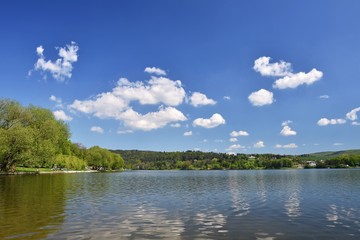 Fototapeta na wymiar Pond with forest and blue sky with clouds. Brno Dam recreation spot Czech Republic. Czech Republic, City of Brno - Bystrc - Kninicky.