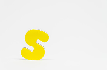 Yellow wooden alphabet S with white background and selective focus