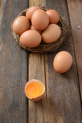 Brown egg in nest on a wooden table