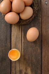 Brown egg in nest on a wooden table