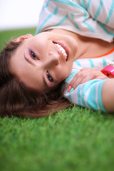 Obraz na płótnie Canvas Beautiful young woman lying on green grass
