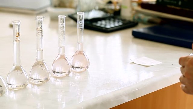 Transparent liquid in flasks on a table in a laboratory