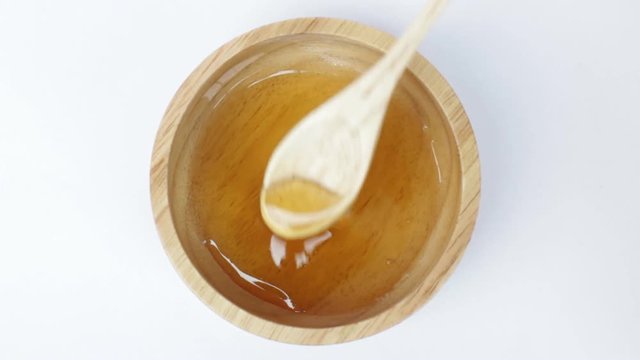 Wooden spoon of honey cup on top view, stock video