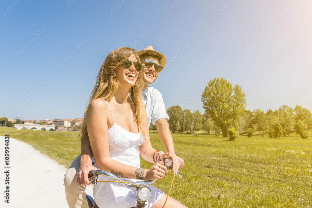 Wall mural happy couple riding bikes in the park