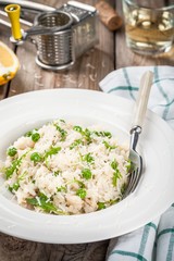 Homemade risotto with chicken, green peas, arugula and parmesan