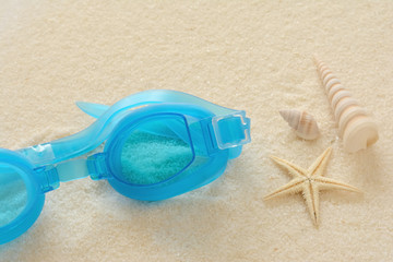 Fototapeta na wymiar 水中眼鏡と貝殻とヒトデ　白砂背景