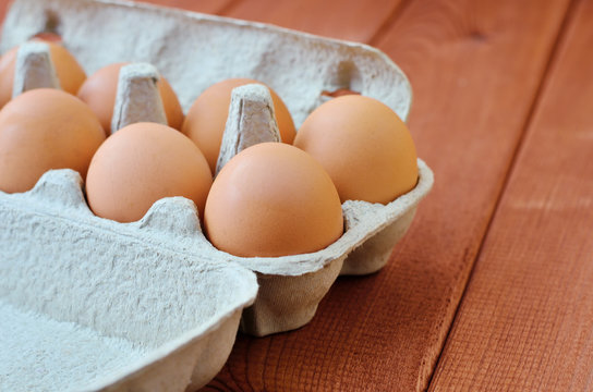 Eggs in container on a wooden background. Side view