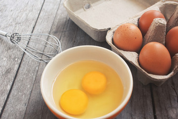 Eggs in box and bowl with whisk