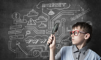 Curious school boy with magnifier