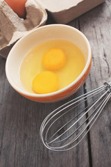 Eggs in box and bowl with whisk