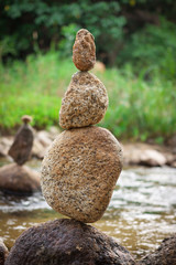 Stacked stones on green blurry background