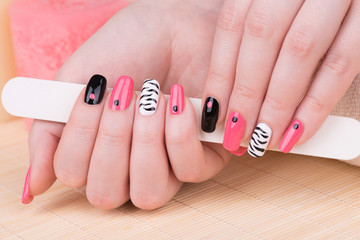 Manicure - Beautifully manicured woman fingernails. Feminine nail art with interesting animal print nail art.
