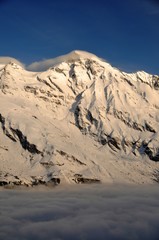 mountain peak with cloud hood and fog
