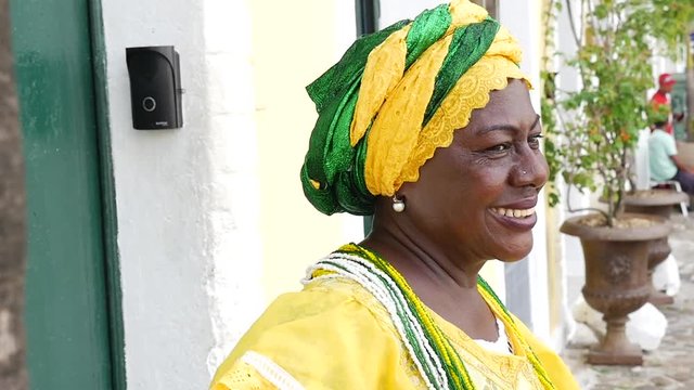 Brazilian woman of African descent, smiling, dressed in traditional Baiana attire in Pelourinho, Salvador, Bahia, Brazil