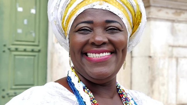 Brazilian woman of African descent wearing traditional clothes from the state of Bahia in the old colonial district of Salvador (Pelourinho), Brazil