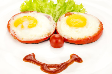 eggs as a smiley face adorned with greenery on a white plate