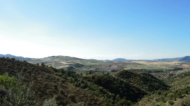 Mediterranean landscape with wind turbines energy at horizon at sunset