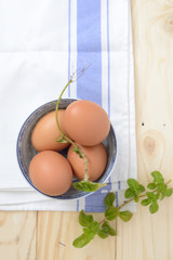 brown eggs in a bowl with mint leaf on a napkin closeup