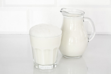 Glass of butttermilk on white table