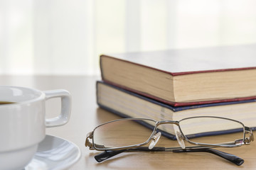 Book and Eyeglasses on a wood table
