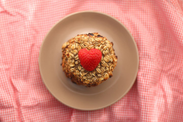 Simple cookies prepared with two ingredients: oatmeal and mashed bananas. Decorated with strawberry. Top view, selective focus. 