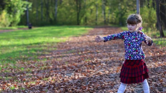 Cute little girl plays as archer in sunny autumn park