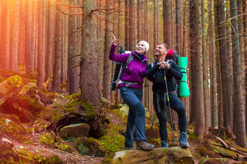 Man and Woman Hikers Staying in Dense Old Forest Smiling and Pointing