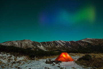 Polar Night landscape with illuminated tent and Polar Lights