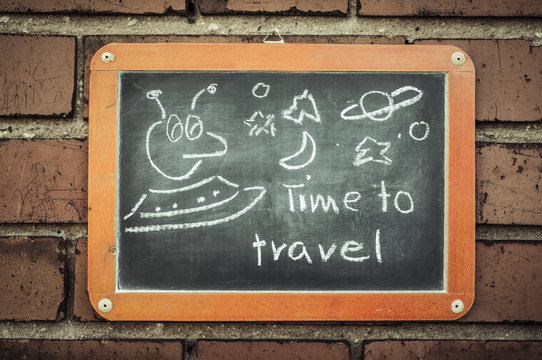 Tafel an einer Ziegelwand mit Text / Tafel an einer Ziegelwand mit Text Time to travel.