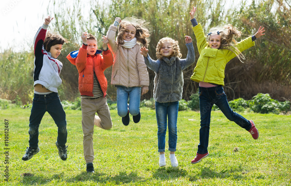 Wall mural Children jumping outdoors .