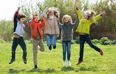 Children jumping outdoors .