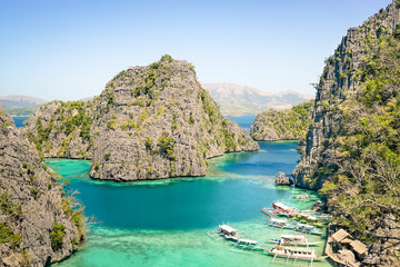 Blue lagoon with longtail boats by Karangan Lake in Coron Palawan - Philippines nature wonders