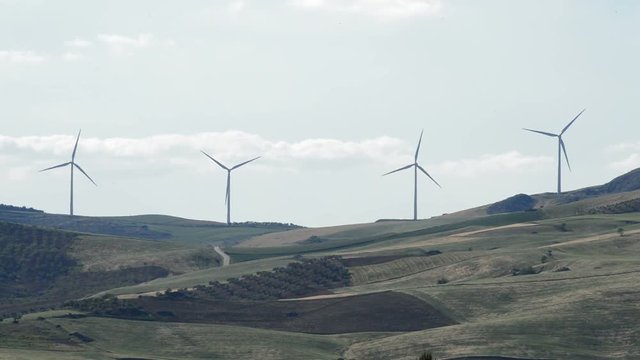 Wind turbines energy rotating in the mountain with blue sky
