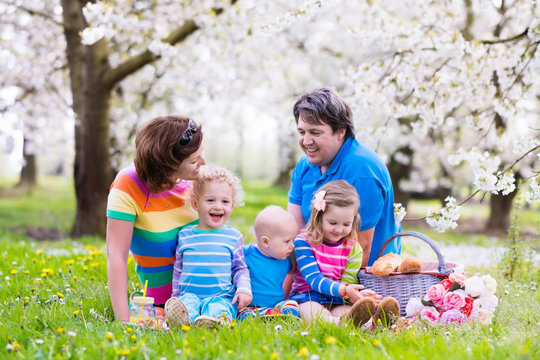 Family with children enjoying picnic in spring park