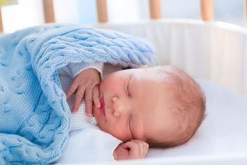 Newborn baby boy in hospital cot