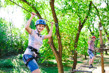 Fototapeta premium adventure climbing high wire park - people on course in mountain