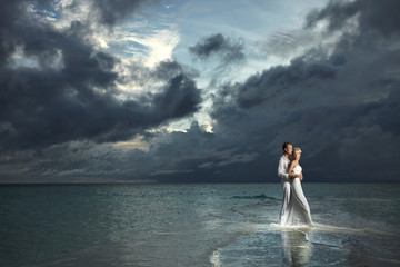 Wedding couple, bride and groom standing under threatening cloud