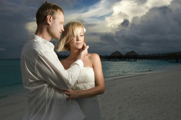 Wedding couple, bride and groom standing under threatening cloud