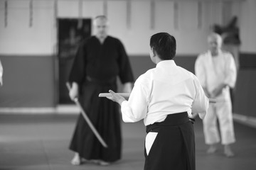 Aikido practice with wooden sword, monochrome